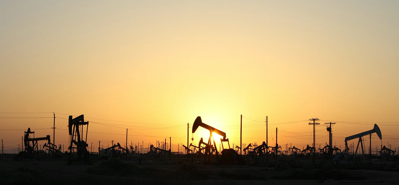 Gün batımında petrol sahasındaki kuyu pompaları (arşiv)