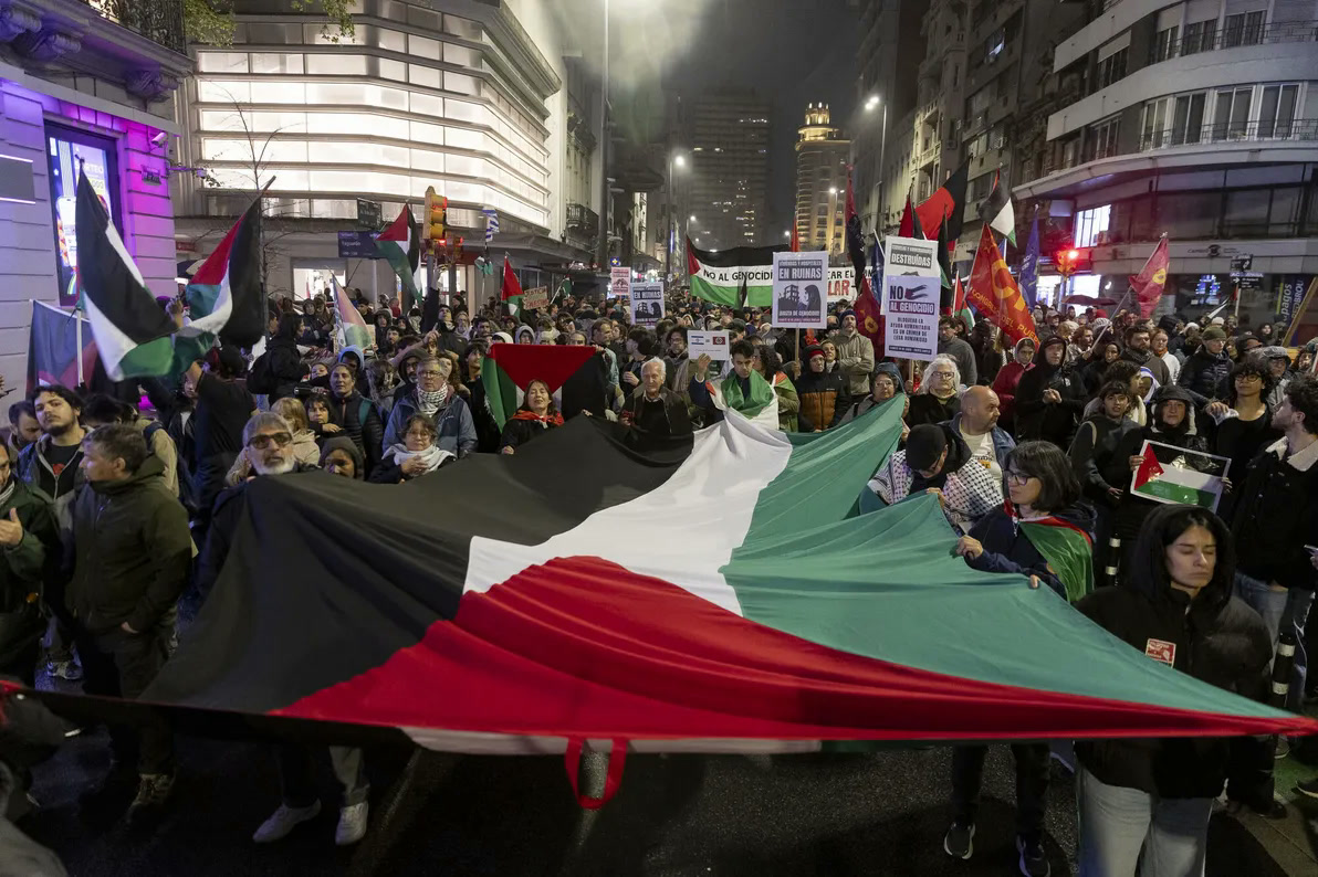 متظاهرون يحملون علما فلسطينيا ضخما في مونتيفيديو