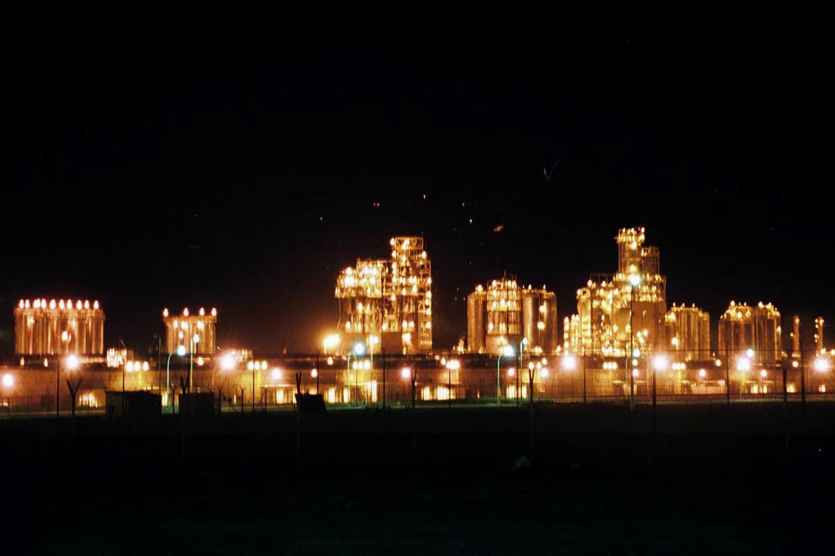 Gece ışıklandırılmış bir petrol rafinerisi (arşiv)