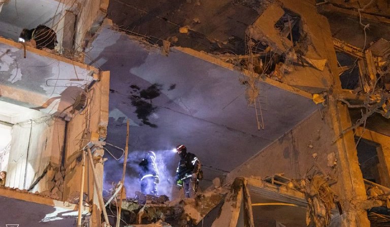 Rescuers inside a damaged apartment block in Kharkiv